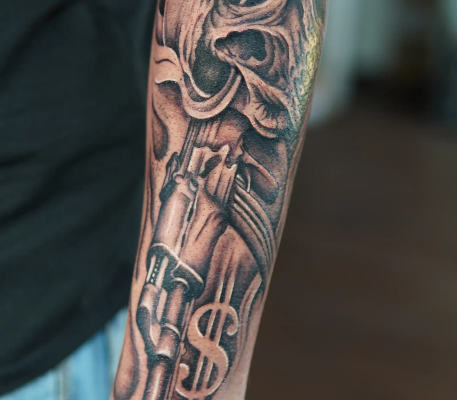 Detailed black-and-grey ornamental tattoo covering the forearm
