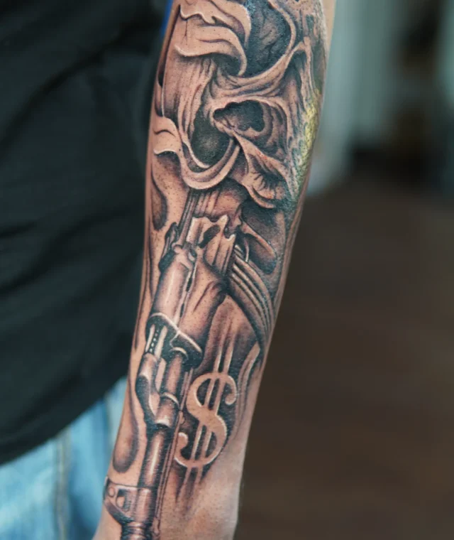 Detailed black-and-grey ornamental tattoo covering the forearm